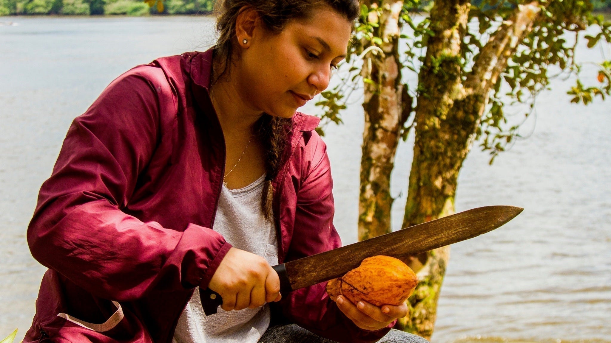 Luisa Abram cracks cacao with a machete